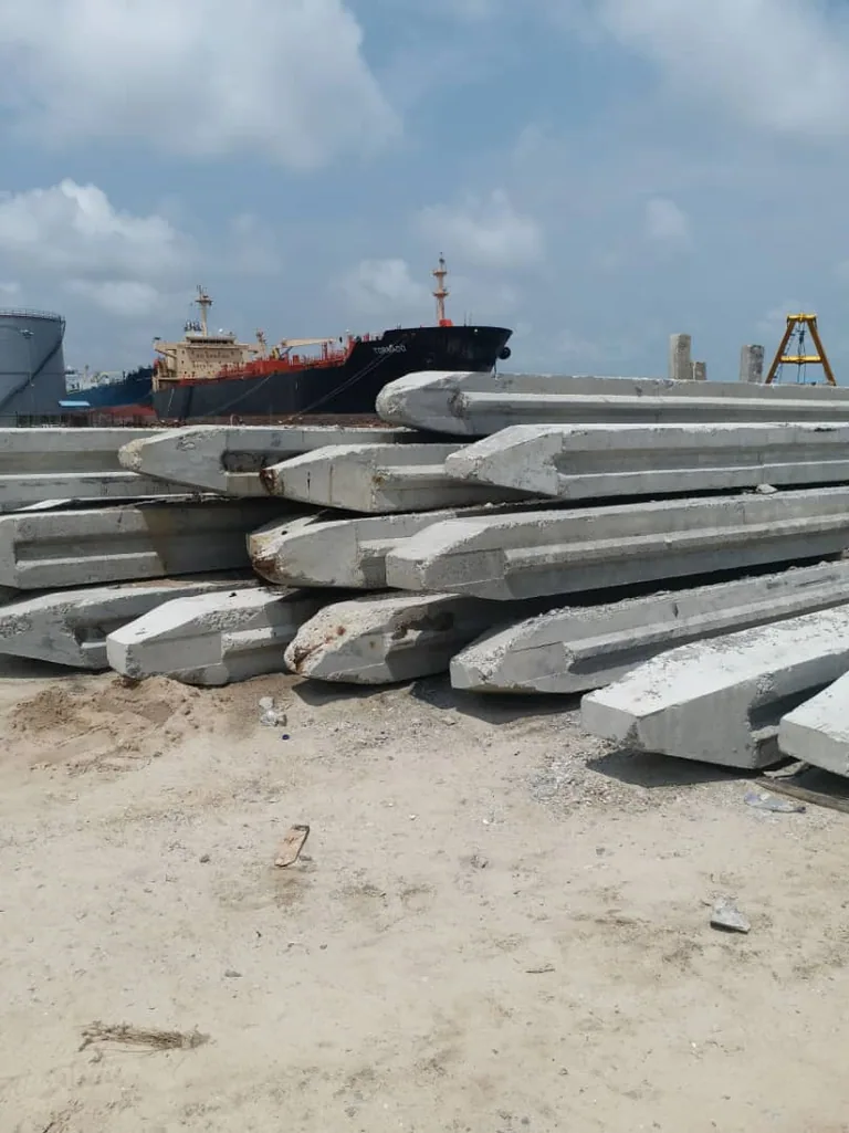 Stacked concrete coastal protection elements beside a waterfront